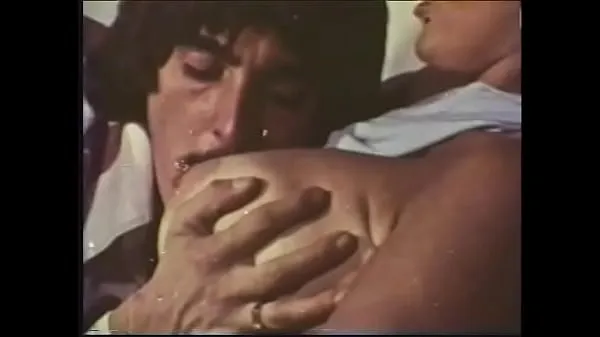 A mustachioed dude with long sideburns caresses an experienced blonde with huge buckets in a 70s video Video mới lớn